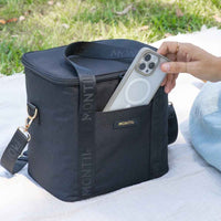 
              Black cooler bag with 'Montii' branding on a grassy background
            