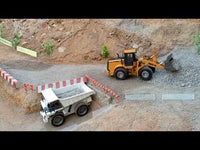 
              Remote controlled 1567 front loader driving around a small quary and lifting a load of gravel
            