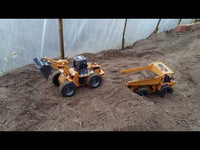 
              video of Huina 1520 front loader driving along sand and then  dumping a load of sand into the back of a dump truck.
            